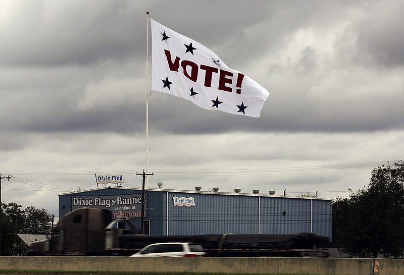 In this Nov. 8, 2016, file photo, a huge "Vote!" flag waves above Interstate 35 as motorists pass in San Antonio.