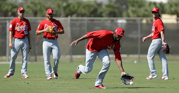 Cardinals outfielder Dexter Fowler fields a ball during a spring training workout Friday in Jupiter, Fla.