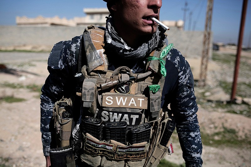 A member of the federal police smokes a cigarette during a break in fighting against Islamic State militants, in Hamam al-Alil, Iraq, Sunday, Feb. 19, 2017. U.S.-backed Iraqi forces launched a large-scale military operation on Sunday to dislodge Islamic State militants from the western half of Mosul city.