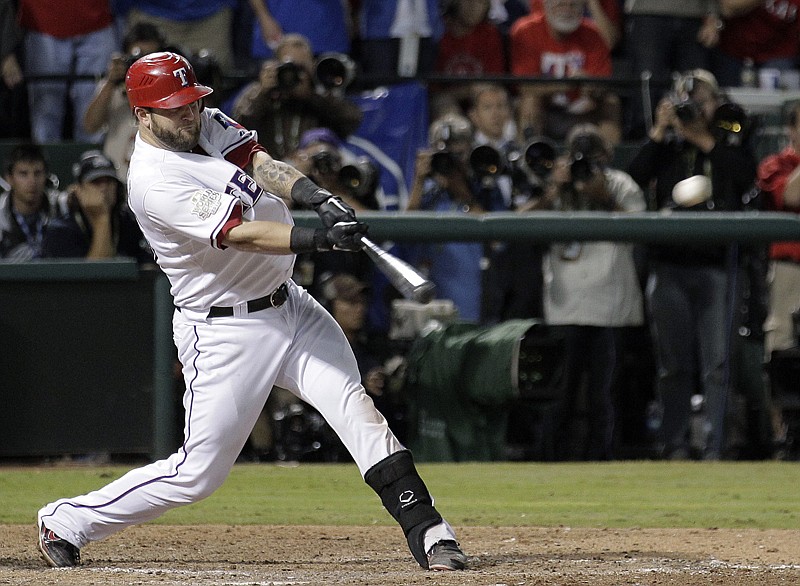 Texas Rangers' Mike Napoli hits a two-run double during the eighth inning of Game 5 of the World Series against the St. Louis Cardinals on Oct. 24, 2011, in Arlington, Texas. The Rangers' reunion with slugger Napoli has changed the outlook this season for young players in the organization.