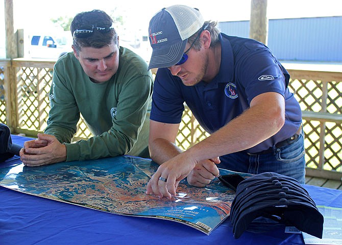 Richie Blink, left, of the National Wildlife Federation, and Ben LeBlanc, president of LeBlanc Marine Construction, look over a map of the area where a reef was constructed from recycled oyster shells in St. Bernard Parish, Louisiana, in November. The oyster shell recycling program spearheaded by two environmental groups in coordination with area restaurants aims to take a waste product that used to fill landfills and instead make it into a structure that tiny oyster larvae can latch onto and grow. 