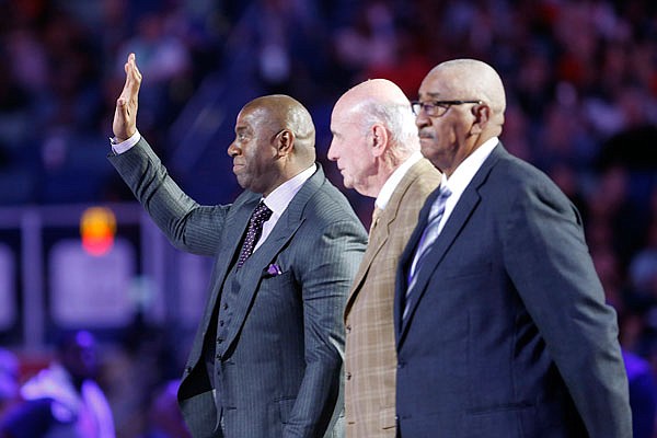 NBA Legend Magic Johnson waves as he is introduced with fellow legends Bob Pettit and Willis Reed during the first half of the NBA All-Star Game Sunday in New Orleans.