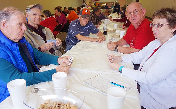 Chuck and Betty Ball (far left and far right) face off over cards while (left to right) Bob Schuck, Earl Ingram and Walter William look on. The Mexico card-playing group comes down to Loafer's Week every year. 