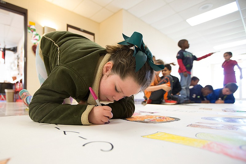 Winter Dillard and other second-graders put the finishing touches on a Black History Month poster they created in Ms. Couch's class Thursday at Pleasant Grove Elementary School. The 20-foot banner will be hung in the hallway on the elementary campus.