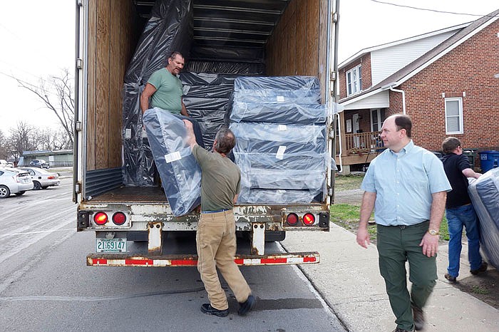 On Thursday, Roger Holliday, a trucker from Arnold (in the trailer), brought a load of new mattresses to the Wiley House, an overnight shelter for single men and women in Fulton. The new mattresses were purchased with a donation, according to Brad Sheppard (right), executive director of Our House: Caring for Callaway's Homeless. 