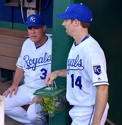 Billy Burns of the Royals walks past manager Ned Yost carrying Rally Mantis Jr. in his cage prior to a game last season at Kauffman Stadium.