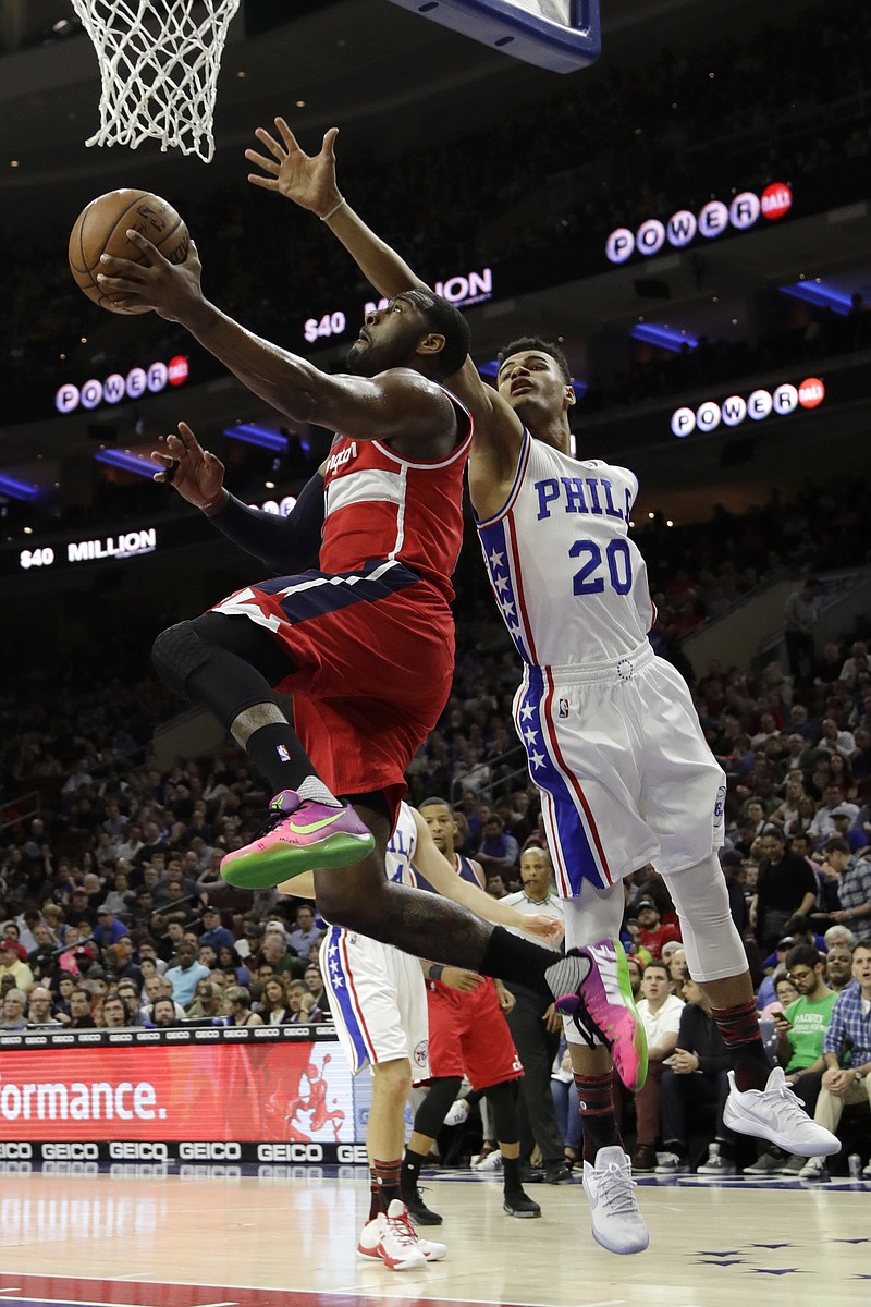 Washington Wizards' John Wall, left, goes up to shoot against Philadelphia 76ers' Timothe Luwawu-Cabarrot during the first half of an NBA basketball game, Friday, Feb. 24, 2017, in Philadelphia. 