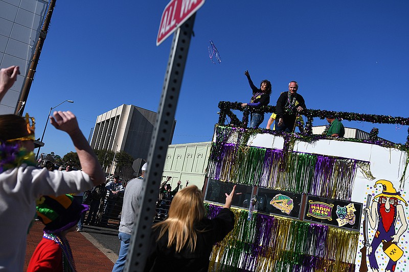 Festival-goers extend their hands hoping to catch beads thrown from the biggest and final float in the parade on Saturday in downtown Texarkana. The event offered vendors, music, food, amusements rides and more.