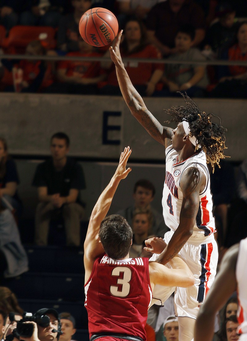 Auburn guard T.J. Dunans (4) shoots over Arkansas guard Dusty Hannahs (3) during the first half of an NCAA college basketball game Saturday, Feb. 25, 2017, in Auburn, Ala. 