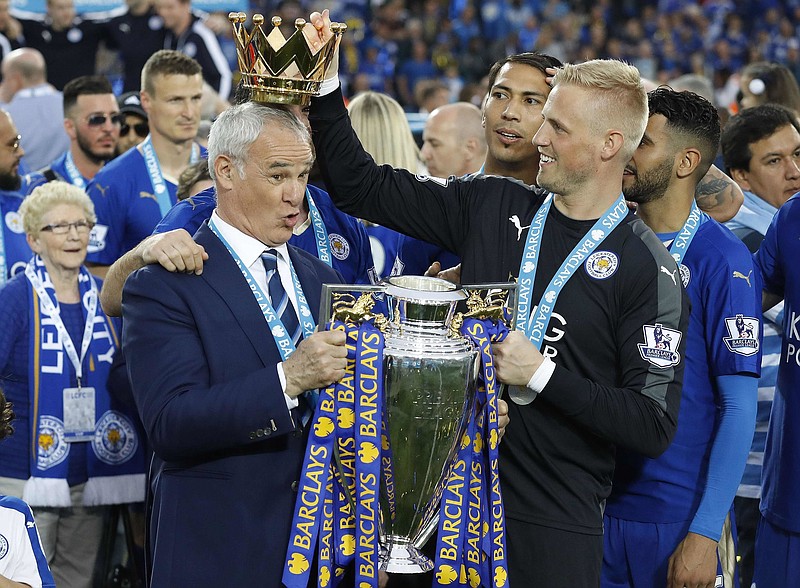 In this Saturday, May 7, 2016 file photo Leicester City team manager Claudio Ranieri has the crown of the trophy placed on his head by Leicester goalkeeper Kasper Schmeichel as they celebrate becoming the English Premier League soccer champions at King Power stadium in Leicester, England. Leicester City announced Thursday, Feb. 23, 2017 that they have sacked manager Claudio Ranieri less than a year after their incredible run to the Premier League title.