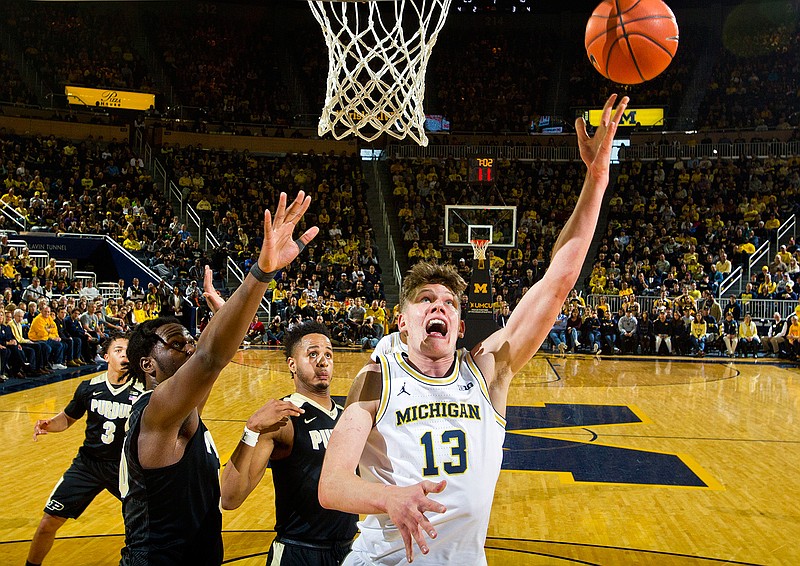 Michigan forward Moritz Wagner (13), of Germany, makes a basket, defended by Purdue forward Caleb Swanigan, front left, and forward Vincent Edwards, middle, in the first half of an NCAA college basketball game in Ann Arbor, Mich., Saturday, Feb. 25, 2017.