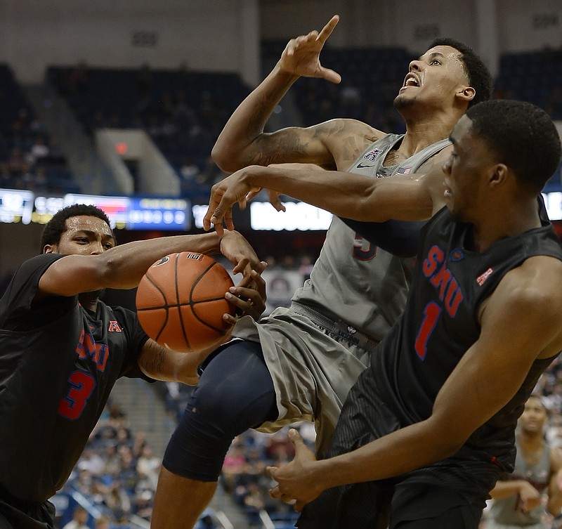 SMU's Sterling Brown pulls the ball from Connecticut's Vance Jackson, center, as SMU's Shake Milton, right, defends, in the second half of an NCAA college basketball game, Saturday, Feb. 25, 2017, in Hartford, Conn.