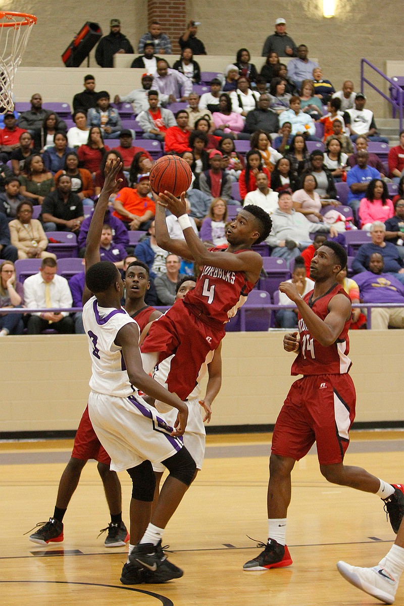 Taviron Oliver drives past a Wildcat defender Saturday in Arkansas High's first 6A conference game at El Dorado, Ark. The Wildcats won, 91-78.
