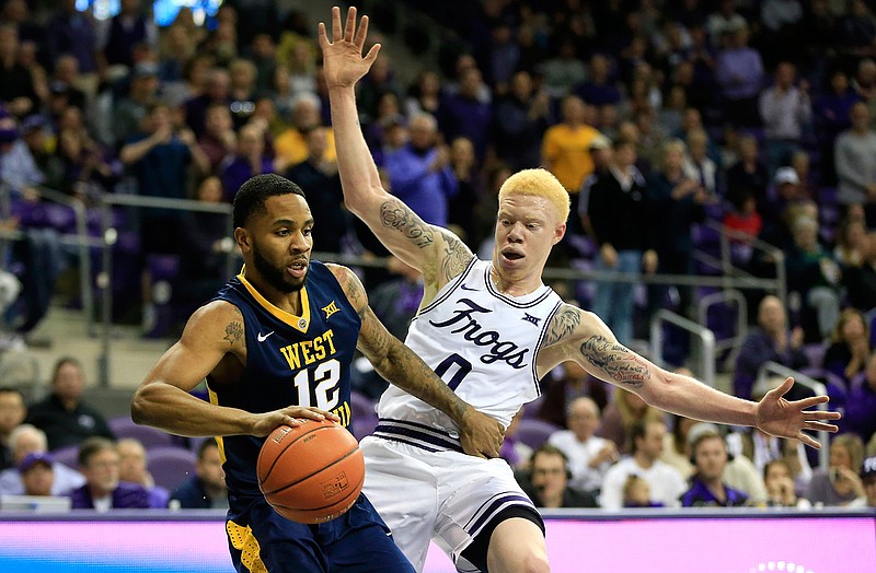 West Virginia guard Tarik Phillip (12) dribbles inside as TCU guard Jaylen Fisher (0) defends in the first half of an NCAA college basketball game, Saturday, Feb. 25, 2017, in Fort Worth, Texas. 
