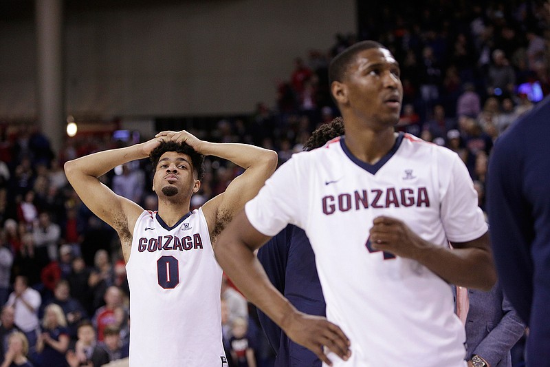 Gonzaga guards Silas Melson (0) and Jordan Mathews (4) stand on the court during senior night speeches after Gonzaga's 79-71 loss to BYU in an NCAA college basketball game in Spokane, Wash., Saturday, Feb. 25, 2017.