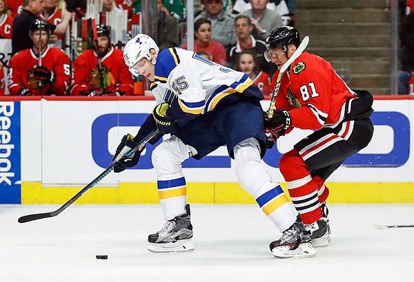 Blues defenseman Colton Parayko protects the puck against Blackhawks right wing Marian Hossa during the first period of Sunday night's game in Chicago.