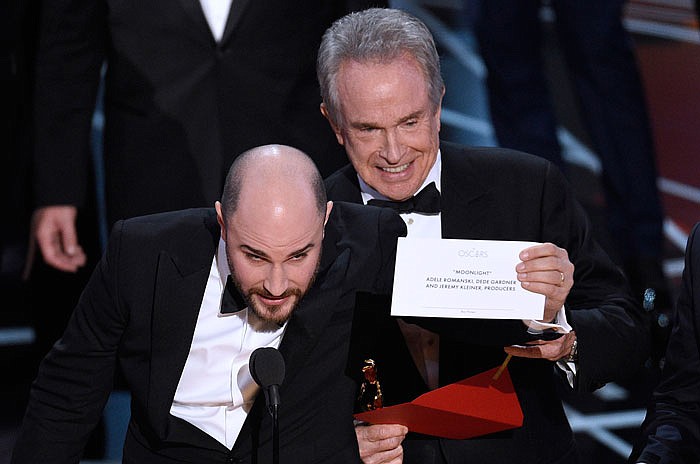 Jordan Horowitz, producer of "La La Land," shows the envelope revealing "Moonlight" as the true winner of best picture at the Oscars on Sunday. Presenter Warren Beatty looks on from right. 