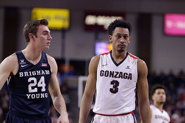 BYU forward Davin Guinn and Gonzaga forward Johnathan Williams stand on the court during the first half of Saturday's game in Spokane, Wash.