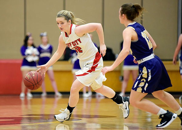 Lady Jays guard Sarah Hirst dribbles the ball to her right to avoid a Troy defender during the second half of Monday night's Class 5 District 8 semifinal game at Fleming Fieldhouse.