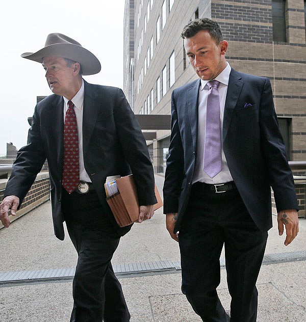 Former NFL quarterback Johnny Manziel (right) walks with his lawyer Jim Darnell after a court hearing Tuesday in Dallas.