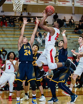 Rae'Quan Davis of Jefferson City goes up for a shot against Alex Smith of Battle during Thursday night's game at Fleming Fieldhouse.