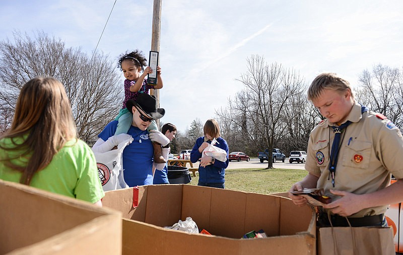 Scouts and volunteers sort various items into boxes as donors pass through. In Jefferson City, donations will remain at the Samaritan Center while troops from Russellville, Linn and California will deliver donations to their local food banks.