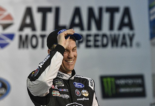Kevin Harvick stands in Victory Lane after winning the pole for the NASCAR Monster Energy Cup auto race at Atlanta Motor Speedway in Hampton, Ga., Friday, March 3, 2017. 