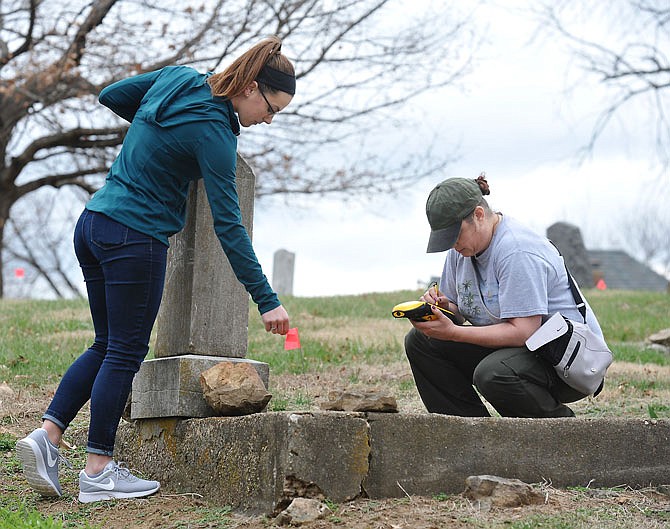 Amber Odom, left, and Rachel Barnard record the exact location of a headstone in Old City Cemetery on East McCarty Street. Odom, a senior, and Barnard, a junior, are students in Samson Tesfaye's Fundamentals of GPS at Lincoln University who spent an hour in Old City Cemetery Monday record to gravesites.