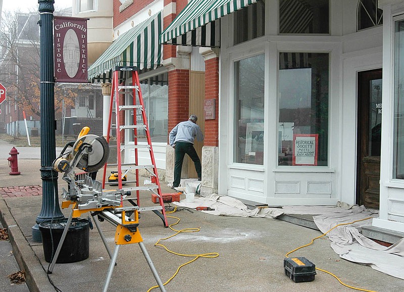 Jim Caton, employee of Stahl Construction, does some final painting on the High Street side of the Moniteau County Historical Society building in California. In addition to paint, the work involved replacement of deteriorated wood and changes to step angles to reduce future damage of the old building.