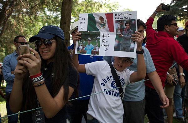 A fan of Rory McIlroy holds up pictures of him during Sunday's final round of the Mexico Championship at Chapultepec Golf Club in Mexico City.
