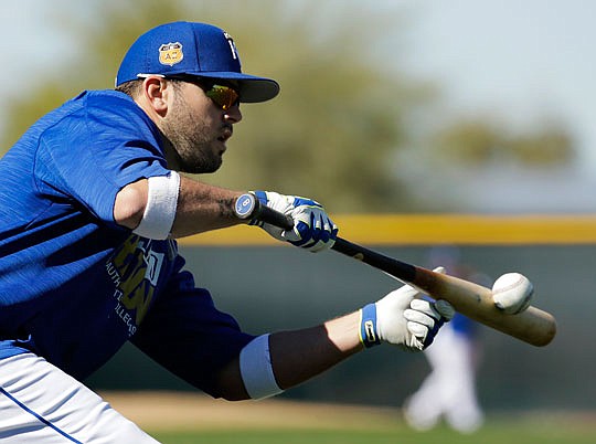 Mike Moustakas of the Royals lays down a bunt during a practice session last month in Surprise, Ariz.