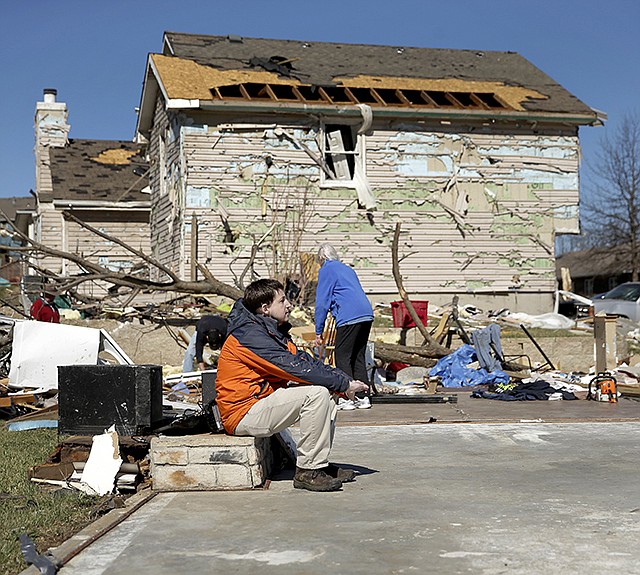 Mark Swartz sits in what was the living room of his home as he salvages items Tuesday after it was destroyed by a tornado, when a severe storm passed through Oak Grove on Monday night.