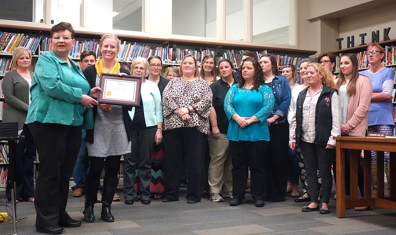 Foreground, left: Pamela Speer, executive director of Missouri Accreditation, presents the accreditation certificate to Fulton Education Center Director Jennifer Meyerhoff, foreground, right. Almost the entire staff of the Education Center came to celebrate the moment.