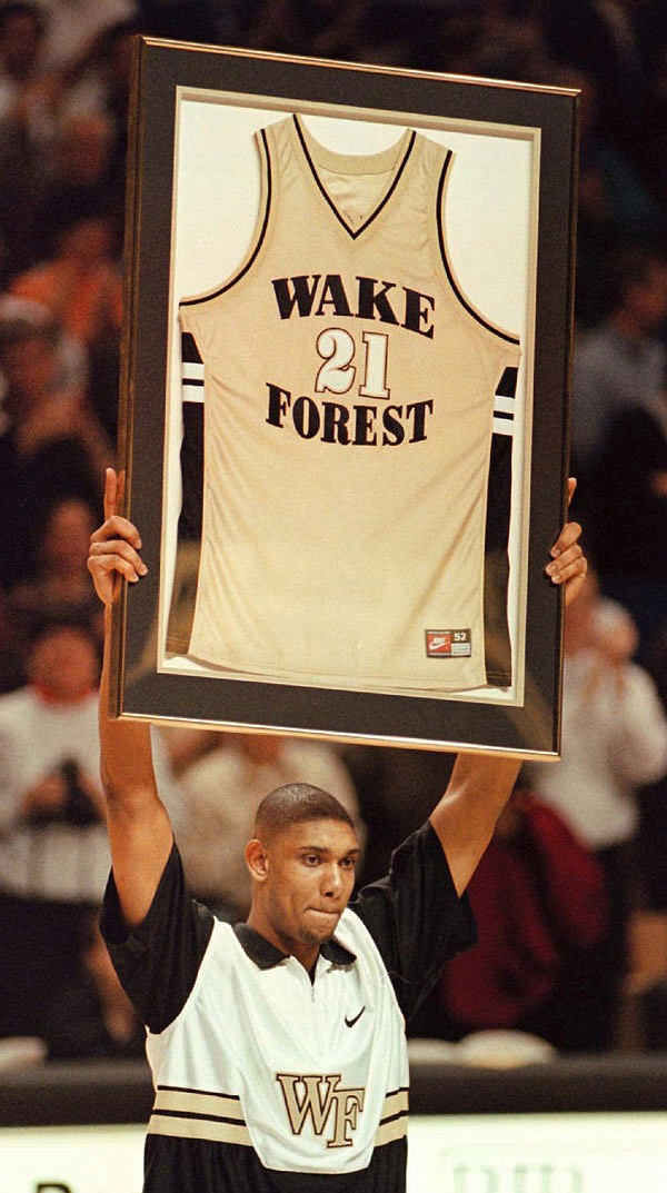 In this Feb. 25, 1997, file photo, Wake Forest center Tim Duncan shows his jersey to the crowd after his jersey was retired at his last home game at Joel Coliseum in Winston-Salem, N.C.