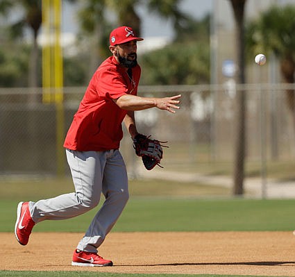 Matt Carpenter of the Cardinals tosses a ball to first base during a drill last month in Jupiter, Fla.