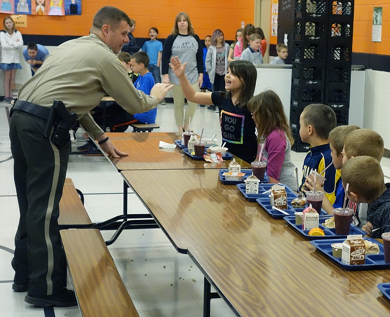 Callaway County Sheriff Clay Chism gets a big high-five from 8-year-old Erica Ostberg, a second-grade student at New Bloomfield Elementary on Thursday morning. He visited the school for a friendly meet-up with the students.