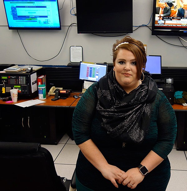 Amber Gann poses for this photo in the 911 Joint Communications Center in Fulton.