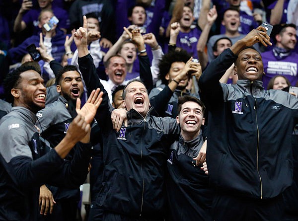 Northwestern coach Chris Collins (center) and his players react as they watch the broadcast of the NCAA Tournament selection show Sunday in Evanston, Ill. Northwestern, making its first tournament appearance, will play Vanderbilt in the first round.