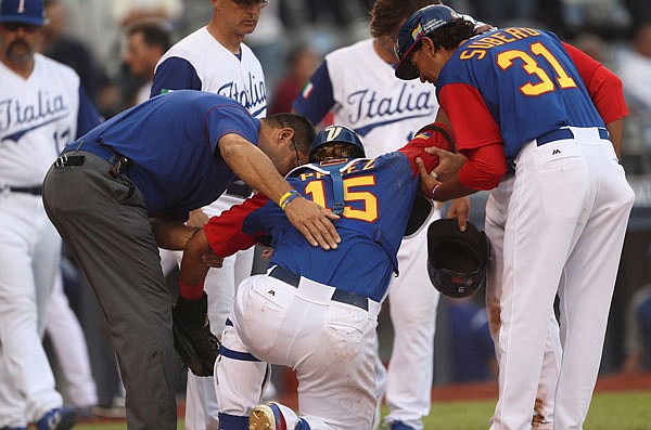 Venezuela catcher Salvador Perez is helped after being injured during Saturday night's World Baseball Classic game against Italy in Guadalajara, Mexico. The Royals All-Star catcher injured his left knee in a home-plate collision with Royals backup catcher Drew Butera in the ninth inning.