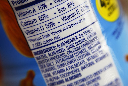 This Thursday, Feb. 16, 2017, photo shows the ingredients label for almond milk at a grocery store in New York. Dairy producers are calling for a crackdown on the almond, soy and rice "milks" they say are masquerading as the real thing and cloud the meaning of milk for shoppers. A group that advocates for plant-based products has countered by asking the Food and Drug Administration to say foods can use terms such as "milk" and "sausage," so long as they're modified to make clear what's in them.