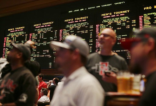 In this March 22, 2013, file photo, odds for second-round NCAA basketball tournament games are displayed on a board at the Mirage hotel-casino Race & Sports Book in Las Vegas. With 70 million-plus office pool brackets, Americans will put in the neighborhood of $2 billion at stake on the NCAA Tournament this week. 