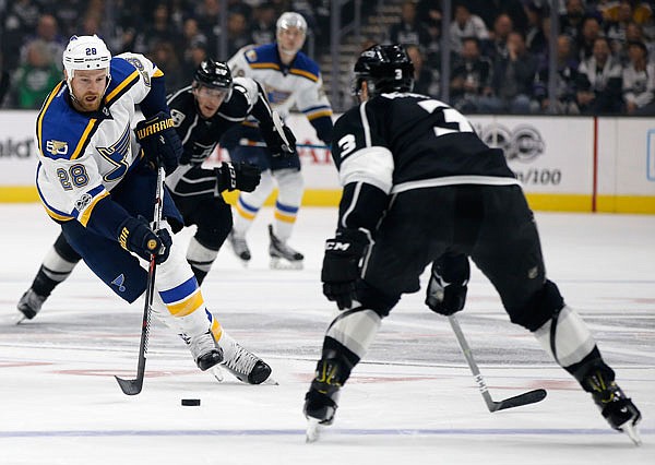 Blues center Kyle Brodziak controls the puck in front of Los Angeles Kings defenseman Brayden McNabb during the first period of Monday's game in Los Angeles.