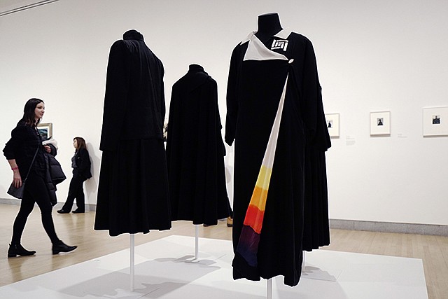 A woman walks by a kimono-style coat, right, on Thursday, worn by artist Georgia O'Keeffe, now on exhibit at the Brooklyn Museum in New York. The show "Georgia O'Keeffe: Living Modern" highlights her role as a style icon.