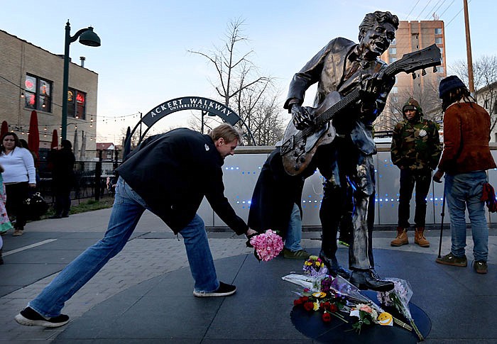 David Gaule, from Springfield, Ill. drops off flowers at the statue of music legend Chuck Berry on the Delmar Loop, in University City. After hearing Berry died Gaule drove to St. Louis from Springfield to pay his respects.