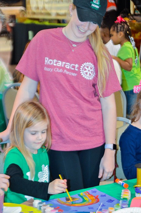 Rotaract Taylor Woods (right) helps Lauren Hanley, four, with her St. Patrick's Day painting. A new addition at this year's mouse race, the kid's craft table helped keep little ones entertained during the event.