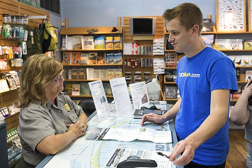 In a Tuesday, March 7, 2017 photo, Park Ranger Kathy Sanders talks with Mikah Meyer, telling him what the he can do at Padre Island National Seashore on his trip to become the youngest person to visit all the National Park Service sites. At 30 years old, Meyer is traveling throughout the United States to become the youngest person to visit all 417 National Park Service sites. 