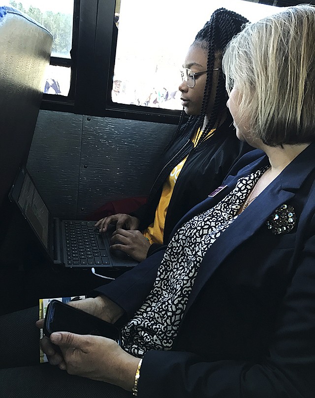 St. Stephen Middle School student Lakaysha Governor works on her Chromebook on a school bus recently outfitted with WiFi by tech giant Google, as College of Charleston professor RoxAnn Stalvey looks on in St. Stephen, South Carolina. Lakysha is one of nearly 2,000 students in South Carolina's rural Berkeley County benefiting from a grant from Google, which on Monday unveiled one of its WiFi-equipped school buses in the area.