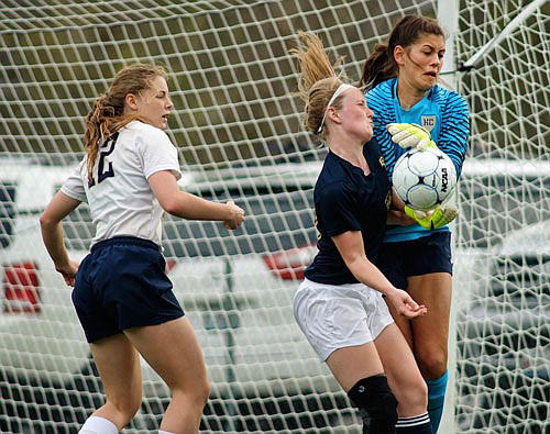 Helias defender Morgan Wieberg (12) watches as Quincy Notre Dame forward Olivia Dreyer collides with Lady Crusader goalkeeper Ashley Rehagen as she makes the save during action last season at the 179 Soccer Park.