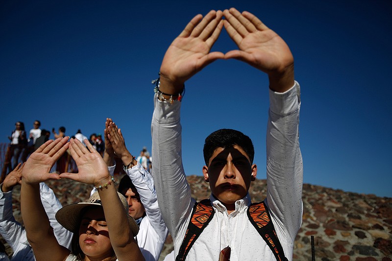 Visitors celebrating the spring equinox atop the Pyramid of the Sun raise their hands toward the sun in the shape of a triangle, at the Teotihuacan archeological site in Mexico, Tuesday, March 21, 2017. Although the official vernal equinox occurred on Monday, thousands of visitors were expected to climb the ancient pyramid between Sunday and Tuesday to greet the sun and celebrate the beginning of spring. 