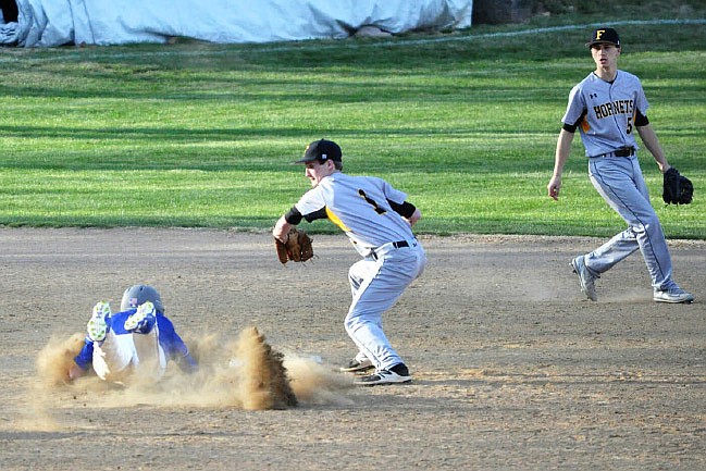 Fulton senior second baseman Josh Quick takes a throw from senior catcher Isaiah Pani and prepares to tag out Boonville left fielder Ethan Waibel on a steal attempt in the Hornets' 11-1 NCMC loss to the Pirates on Tuesday night in Boonville. Senior shortstop Devin Masek backs up Quick on the play.